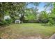 Green backyard with storage shed surrounded by mature trees at 1426 Diamond Head Dr, Decatur, GA 30033
