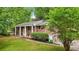 Charming brick home with mature trees, a green lawn, and a welcoming front porch with white columns at 1426 Diamond Head Dr, Decatur, GA 30033