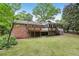 Rear exterior of the home featuring a large wooden deck, brick facade, and enclosed porch at 1426 Diamond Head Dr, Decatur, GA 30033