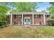 Traditional brick home with white columns, blue door, black shutters, and a well-maintained front lawn at 1426 Diamond Head Dr, Decatur, GA 30033