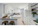 Bright kitchen features white cabinets, stainless steel sink, tile backsplash, and a breakfast bar at 1426 Diamond Head Dr, Decatur, GA 30033