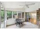 Sunroom with large windows, brick accent wall, and an adjacent hallway with hardwood floors at 1426 Diamond Head Dr, Decatur, GA 30033