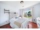 Bedroom featuring hardwood floors, natural lighting, and rustic headboard at 1520 Windsong Park Dr, Dacula, GA 30019
