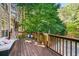 View of an outdoor wooden deck, with outdoor sofa and wooded scenery at 1520 Windsong Park Dr, Dacula, GA 30019