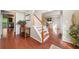 Bright foyer with hardwood floors, staircase, and entry to kitchen at 1520 Windsong Park Dr, Dacula, GA 30019