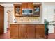 Kitchen island with granite countertop, wood cabinets, and a built-in microwave at 1520 Windsong Park Dr, Dacula, GA 30019