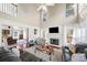 Open living space with high ceilings, a fireplace, hardwood floors, and plenty of natural light from large windows at 1520 Windsong Park Dr, Dacula, GA 30019