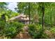 Home with lush backyard landscaping, covered patio, stone pathway, and mature trees at 2140 Azalea Dr, Roswell, GA 30075