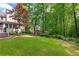 Large, well-maintained backyard with a lush lawn, bordered by mature trees providing privacy at 2140 Azalea Dr, Roswell, GA 30075