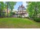Sprawling backyard featuring lush green lawn, mature trees, and a deck with seating area at 2140 Azalea Dr, Roswell, GA 30075