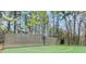 Fenced community basketball court surrounded by trees, offering a private recreational space at 2140 Azalea Dr, Roswell, GA 30075