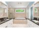 Luxurious bathroom with double vanity, granite counters, soaking tub, and travertine tile at 2140 Azalea Dr, Roswell, GA 30075