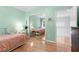 Bright bedroom featuring hardwood floors, light green walls, and mirrored closet doors at 2140 Azalea Dr, Roswell, GA 30075