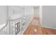 Upstairs hallway with natural light, hardwood floors, and white railings, providing an airy and bright passageway at 2140 Azalea Dr, Roswell, GA 30075