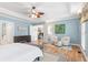 A view of the main bedroom with a sitting area, TV, and ceiling fan enhance the space at 2140 Azalea Dr, Roswell, GA 30075