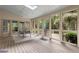 Sunroom showcasing wood flooring, ample windows, and a dining area overlooking a scenic backyard at 2140 Azalea Dr, Roswell, GA 30075