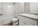 Bright bathroom featuring a shower-tub combo and vanity with a granite countertop and white cabinets at 498 Charleston Pl, Villa Rica, GA 30180