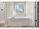 Bathroom featuring a shower and soaking tub, complemented by a large window and a neutral color palette at 498 Charleston Pl, Villa Rica, GA 30180