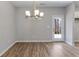 Bright dining room with wood-look floors and modern chandelier, located near an outdoor entry at 498 Charleston Pl, Villa Rica, GA 30180