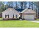 Newly built home featuring a manicured lawn, brick accents, a gray facade and an attached garage at 498 Charleston Pl, Villa Rica, GA 30180