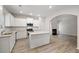 Bright, modern kitchen with white cabinets, island, stainless steel appliances, and view into the living room at 498 Charleston Pl, Villa Rica, GA 30180
