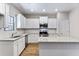 Open kitchen with white cabinets, granite countertops, and stainless steel appliances providing a modern look at 498 Charleston Pl, Villa Rica, GA 30180