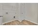 Laundry room with wood-look floors, wire shelving, utility hookups, and a white door at 498 Charleston Pl, Villa Rica, GA 30180
