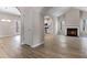 Open-concept living room with a modern fireplace, hardwood floors, and a view into the kitchen at 498 Charleston Pl, Villa Rica, GA 30180