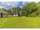 Lush backyard with green grass and mature trees under a bright sky at 67 Jennifer Ln, Rydal, GA 30171