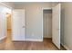 Bedroom with wood flooring, neutral walls, an open closet, and doorways offering a serene space at 67 Jennifer Ln, Rydal, GA 30171
