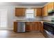 Kitchen featuring wood cabinets, stainless steel appliances, and stylish vinyl flooring at 67 Jennifer Ln, Rydal, GA 30171