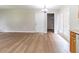 An open living room area with hardwood floors, a white door, and a glimpse of the laundry room at 67 Jennifer Ln, Rydal, GA 30171