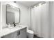 A modern bathroom features a gray vanity, a sleek mirror, and a shower with a white curtain at 726 Edgewood Ne Ave, Atlanta, GA 30307