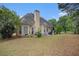 Home's backyard with patio, dining furniture and mature trees at 113 Glenmore Ln, Mcdonough, GA 30253
