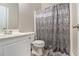 Bathroom with decorative shower curtain, toilet, sink, and wood look floors at 113 Glenmore Ln, Mcdonough, GA 30253