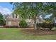 Charming two-story home featuring a brick facade, lush landscaping, and a well-manicured lawn at 113 Glenmore Ln, Mcdonough, GA 30253