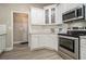 Kitchen with stainless steel range, white cabinets with glass doors and light countertops at 113 Glenmore Ln, Mcdonough, GA 30253