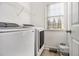 Bright laundry room with modern washer, dryer, and shelving at 113 Glenmore Ln, Mcdonough, GA 30253