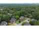 An aerial view shows a neighborhood surrounded by lush trees with the city skyline in the distance at 1703 Brandywine Ct, Atlanta, GA 30338