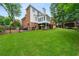 Backyard featuring a lush green lawn, a pergola with seating, and a two-story home at 1703 Brandywine Ct, Atlanta, GA 30338