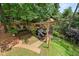 Aerial view of a serene backyard haven featuring mature trees, pergola, brick patio, and verdant lawn at 1703 Brandywine Ct, Atlanta, GA 30338