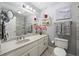 Well-lit bathroom featuring a white vanity, framed art, and a shower with marble tile at 1703 Brandywine Ct, Atlanta, GA 30338