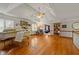 Open living room with coffered ceilings, hardwood floors, a grand piano, and beautiful natural lighting at 1703 Brandywine Ct, Atlanta, GA 30338