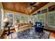 Bright sun room with wood ceilings, large windows, and comfortable seating area at 1703 Brandywine Ct, Atlanta, GA 30338
