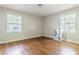 Empty bedroom with hardwood floors, two windows, and a small storage shelf at 2174 Beecher Sw Rd, Atlanta, GA 30311