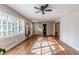 Sun-drenched living room with beautiful hardwood floors and a view of the front yard through large windows at 2174 Beecher Sw Rd, Atlanta, GA 30311