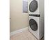 Stacked washer and dryer in the laundry area with tile flooring at 803 Brookhavenrun Cir, Duluth, GA 30097