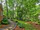 Backyard featuring a stone pathway, manicured landscaping and mature trees, providing a peaceful outdoor space at 1257 Independence Way, Marietta, GA 30062