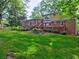 Well-maintained backyard with a spacious lawn, wooden deck and lush garden beds surrounding the home at 1257 Independence Way, Marietta, GA 30062