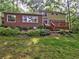 Back exterior of a brick and yellow-sided home featuring a wooden deck and manicured landscaping at 1257 Independence Way, Marietta, GA 30062